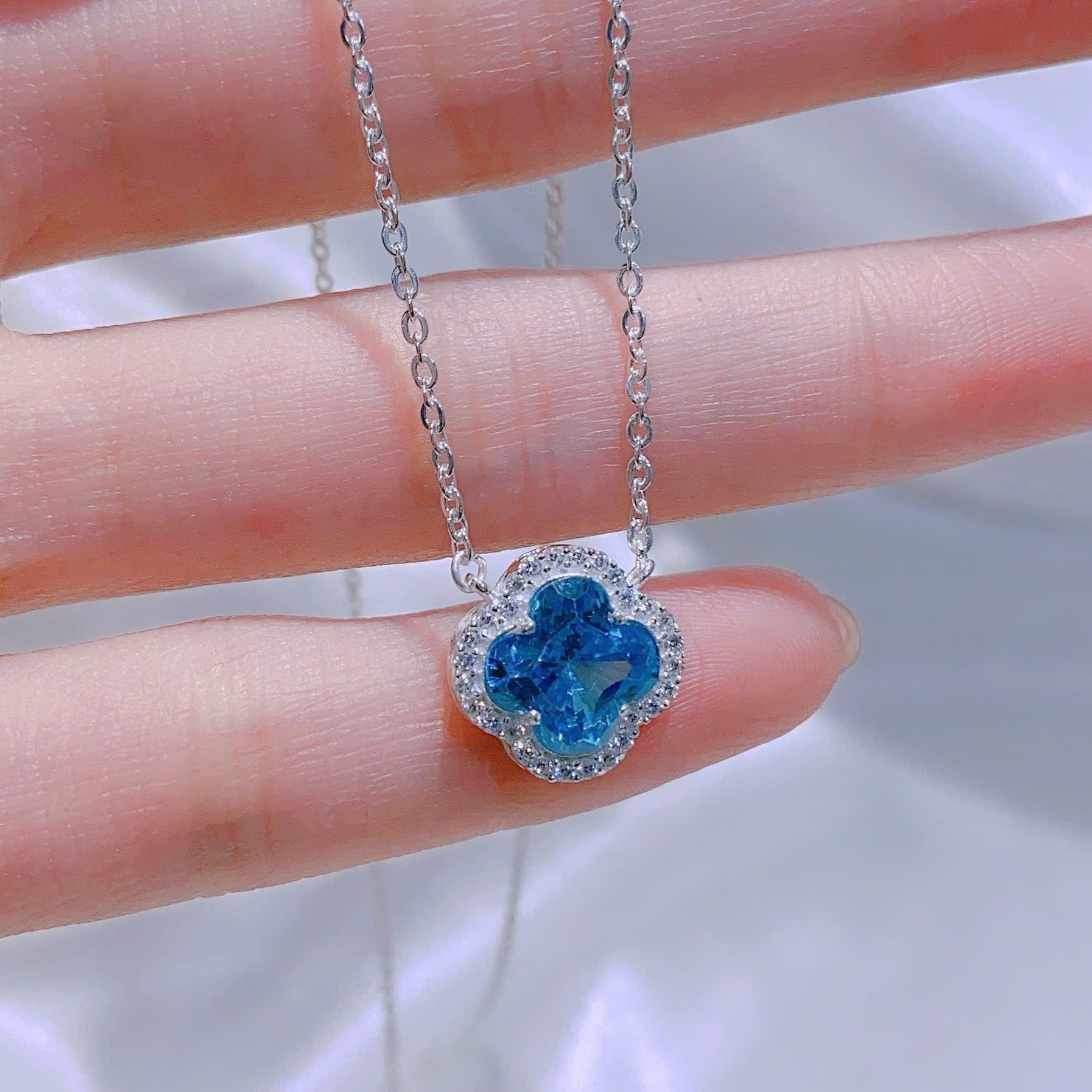 Blue gemstone necklace on a hand with a blurred background