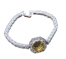 Bracelet with a yellow gemstone and clear stones on a white background