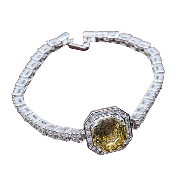 Bracelet with a yellow gemstone and clear stones on a white background
