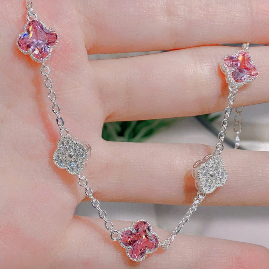 Bracelet with pink flower-shaped charms on a hand, brand 'HLJ63450' visible
