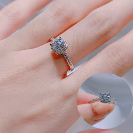 Close-up of a hand wearing a diamond ring with a blurred background