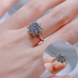 Close-up of a hand wearing a decorative ring with gemstones on a blurred background