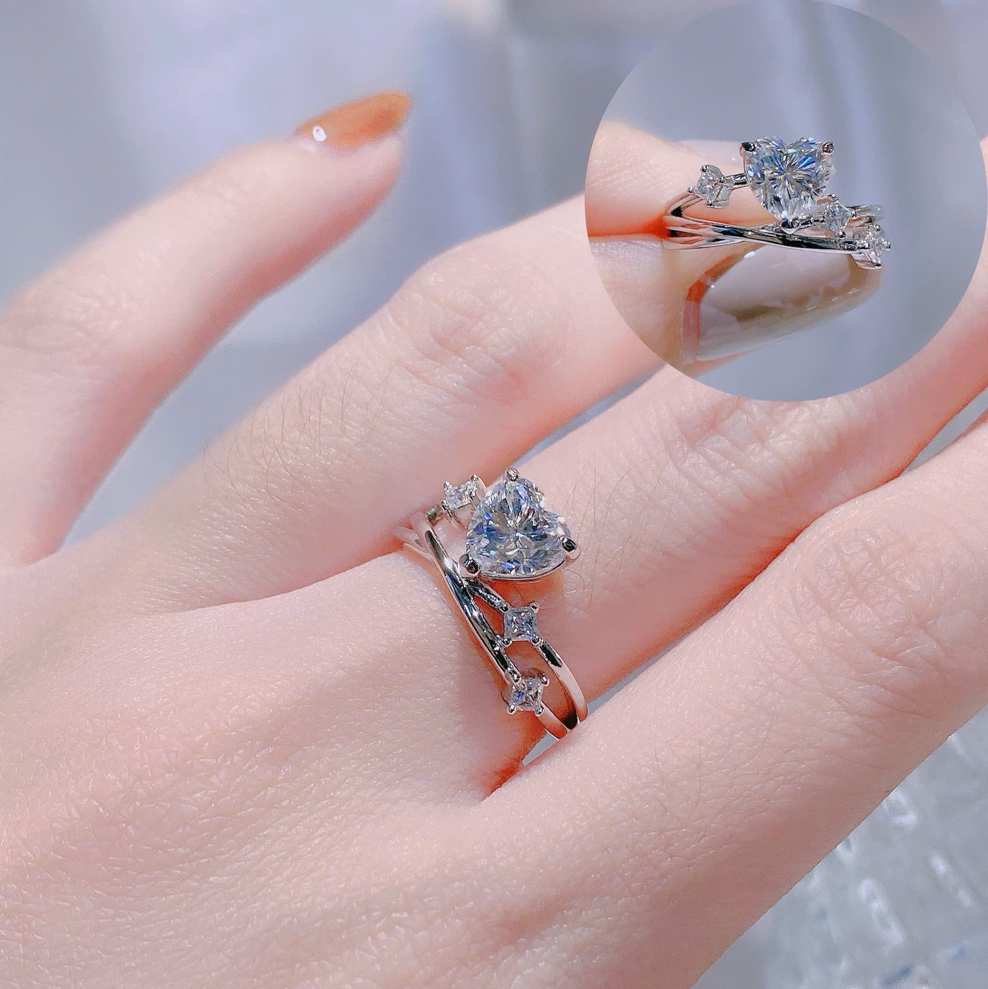 Close-up of a hand wearing two diamond rings with a blurred background