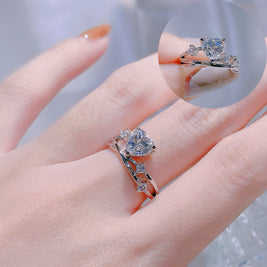 Close-up of a hand wearing two diamond rings with a blurred background