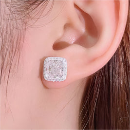 Close-up of an ear wearing a diamond earring with a soft background