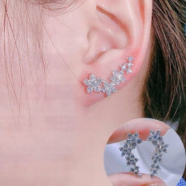 Close-up of an ear wearing a star-shaped earring with a clear background.