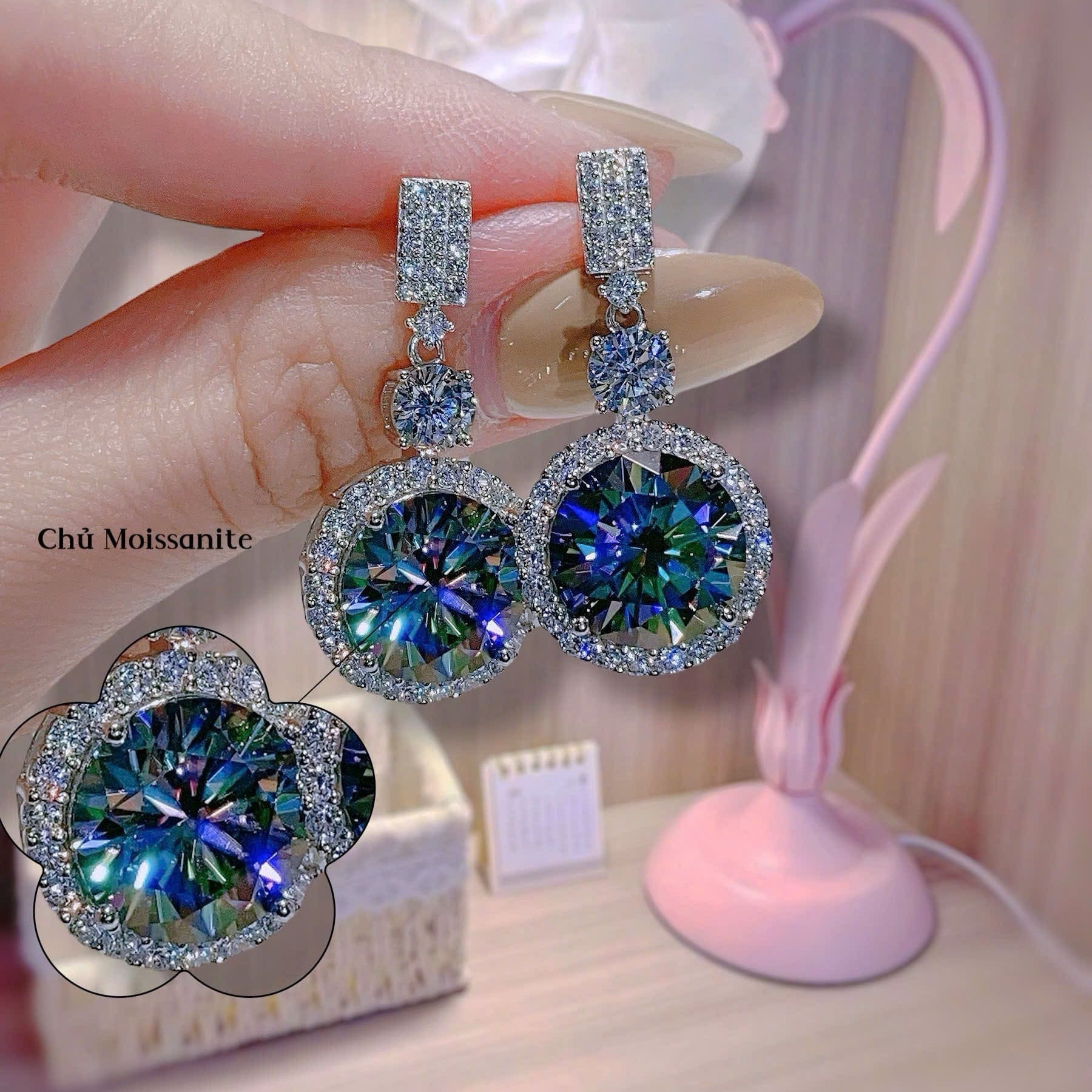 Close-up of diamond earrings held by a hand with a blurred background