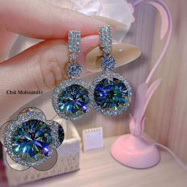 Close-up of diamond earrings held by a hand with a blurred background