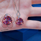 Colorful gemstone earrings on a hand with a blue background