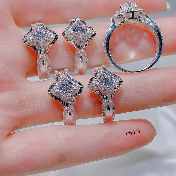 Diamond earrings and ring on a hand with a blurred background