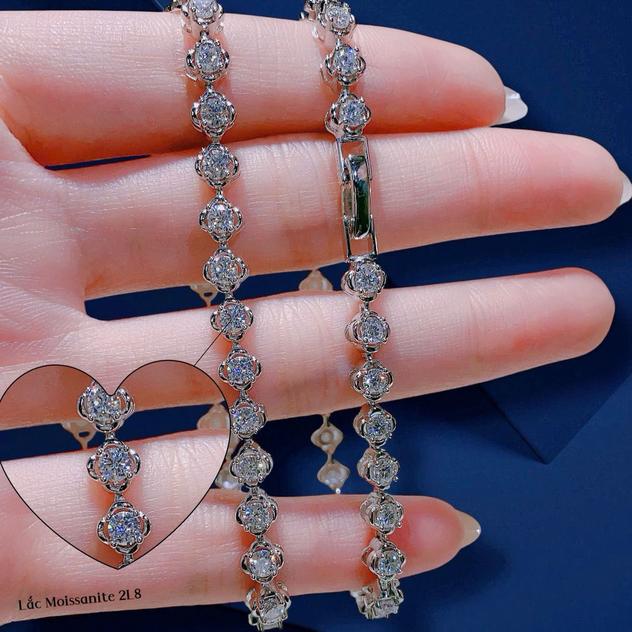 Diamond earrings held by a hand with a blue background