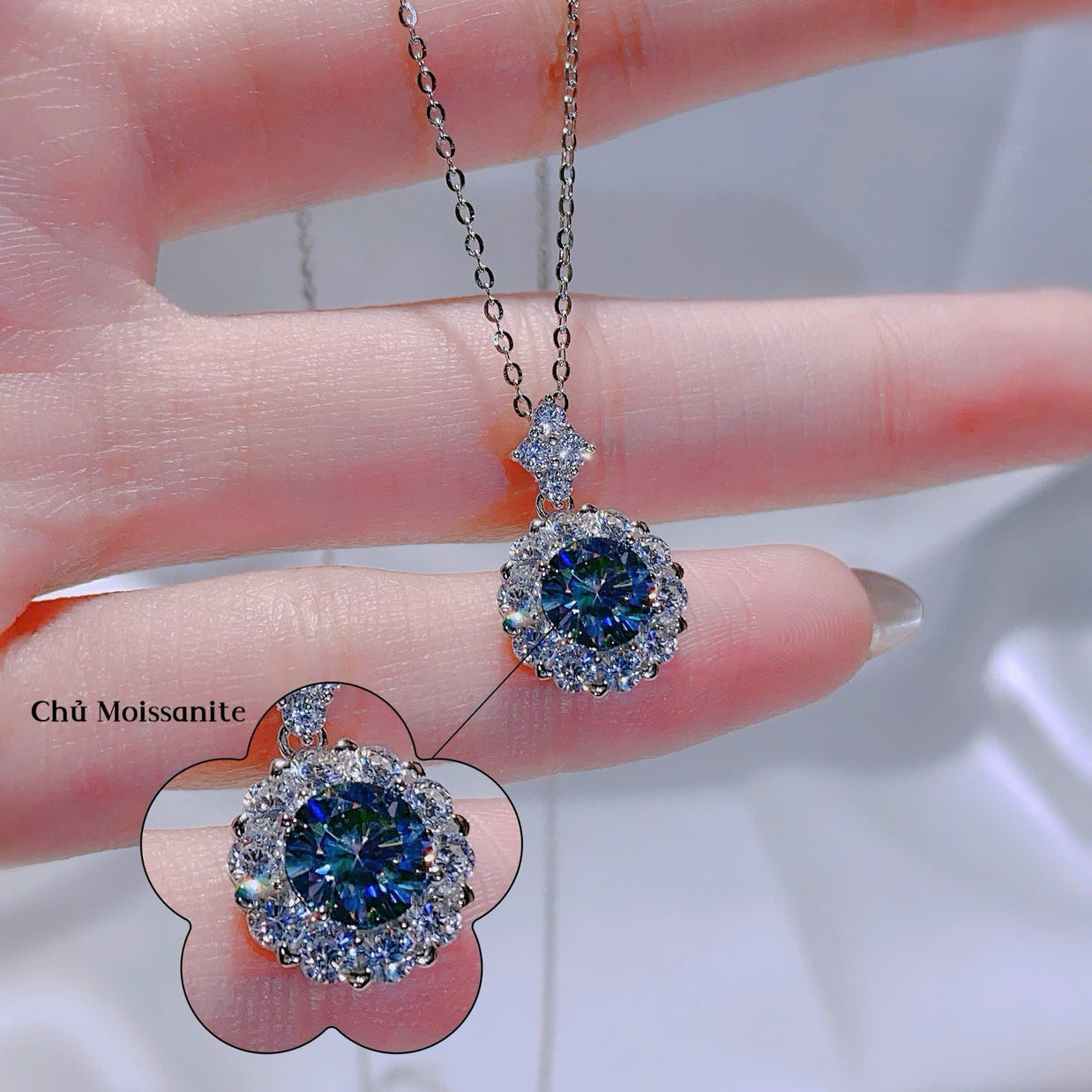 Diamond earrings held by a hand with a blurred background