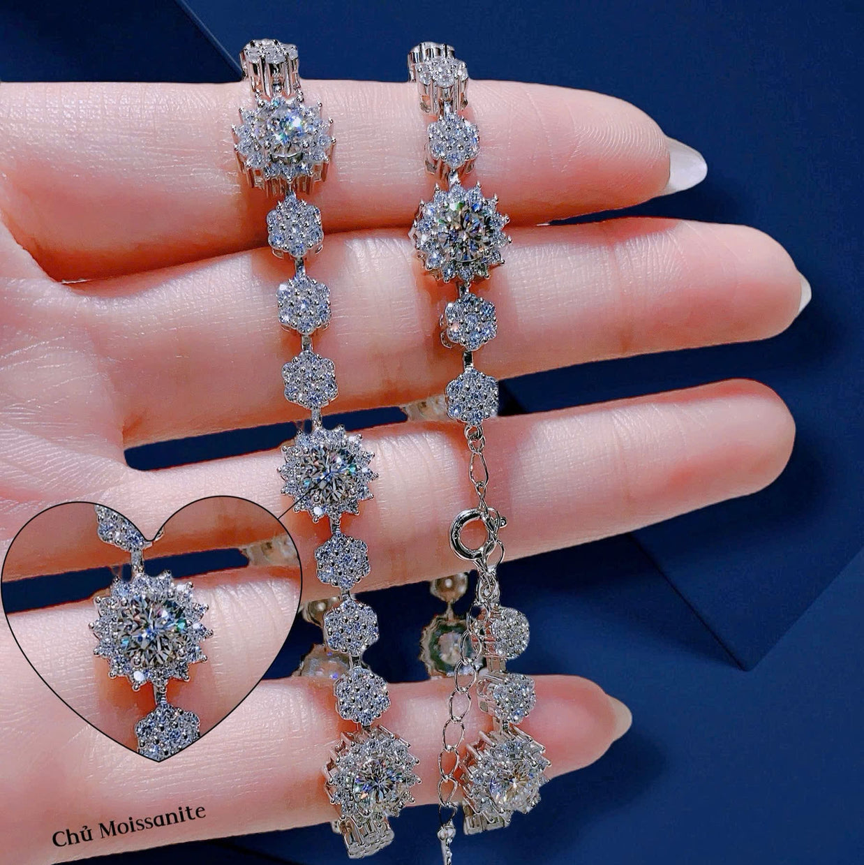 Diamond earrings held in a hand against a blue background