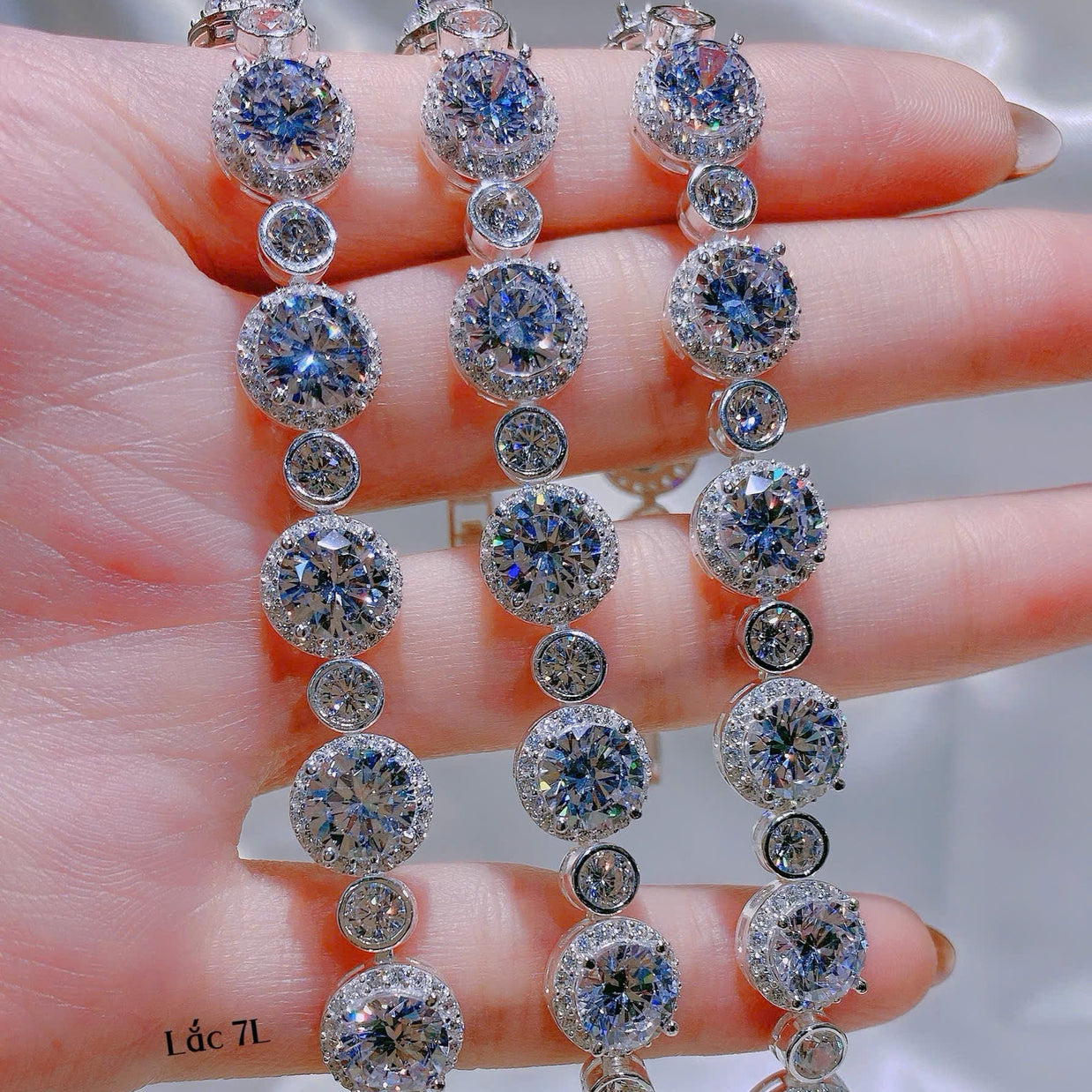 Diamond earrings held on a hand with a blurred background