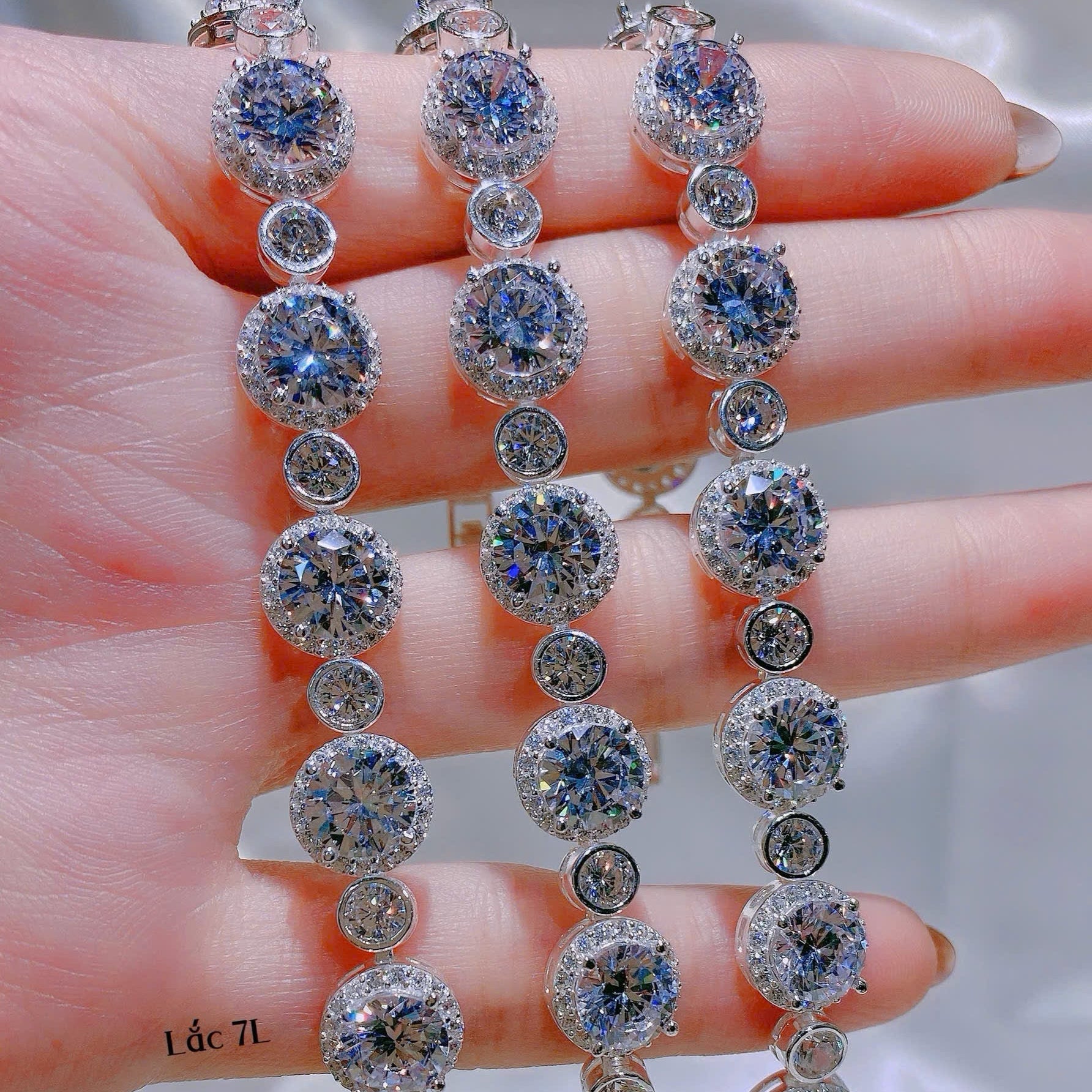 Diamond earrings held on a hand with a blurred background