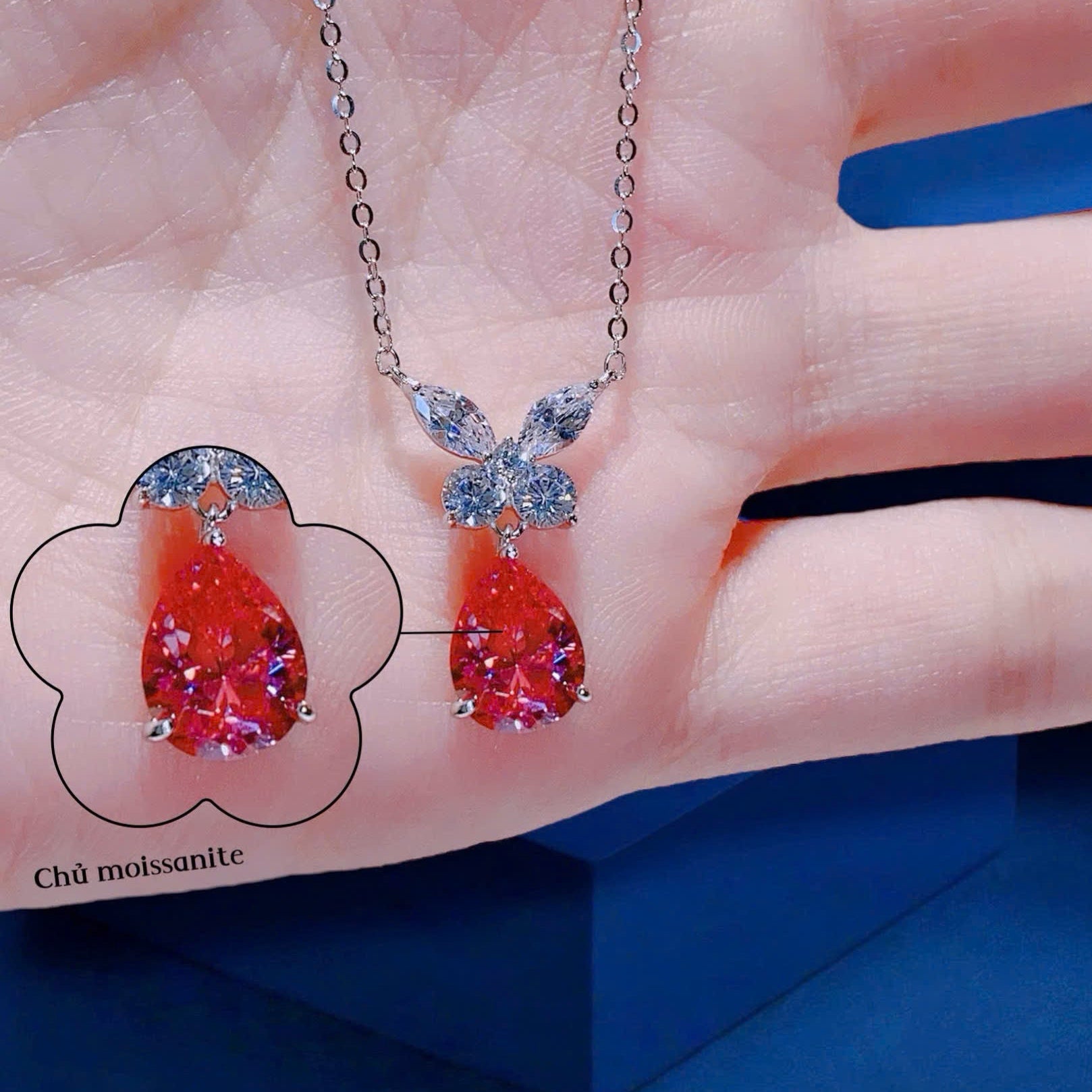 Diamond necklace on a hand with a blue background