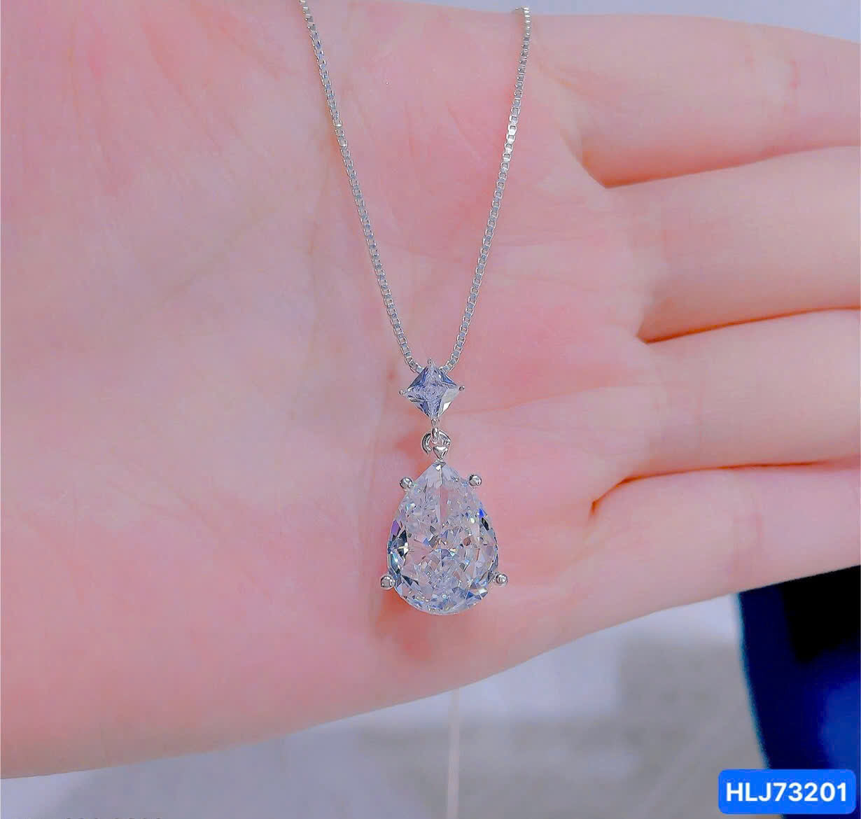 Diamond necklace on a hand with a blurred background