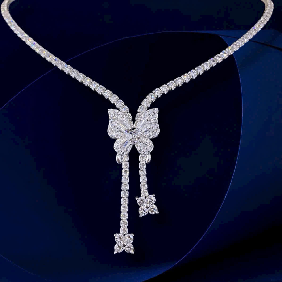 Diamond necklace with a bow-shaped pendant on a dark background