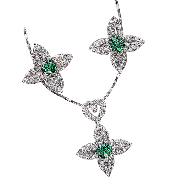 Diamond necklace with emerald stones on a white background