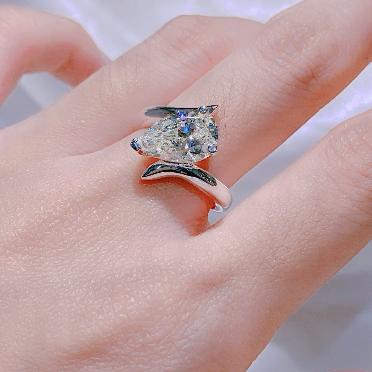 Diamond ring on a finger with a blurred background