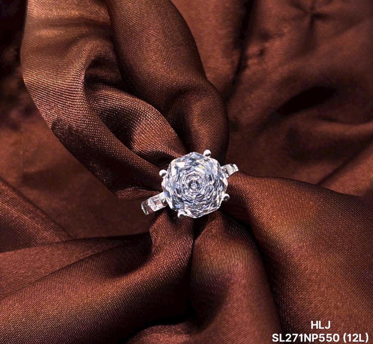 Diamond ring on brown fabric with 'HLJ' branding
