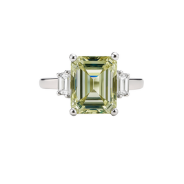 Diamond ring with a green gemstone on a white background