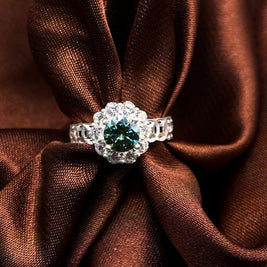 Diamond ring with a green gemstone on brown fabric