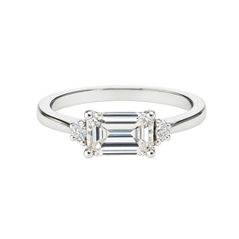 Diamond ring with emerald-cut center stone and smaller side stones on a white background