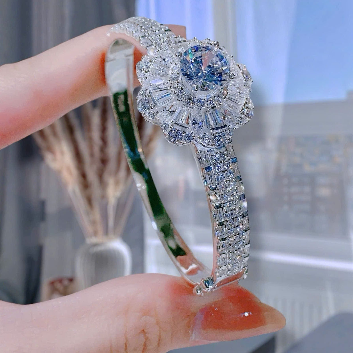 Elegant diamond bracelet held by a hand with a blurred background