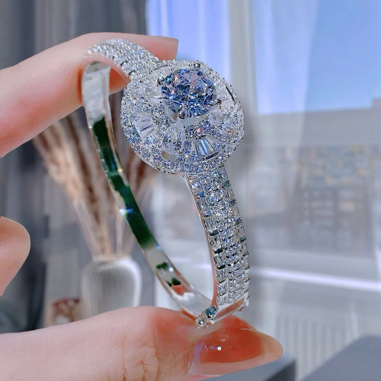 Elegant diamond bracelet held by a hand with a blurred background