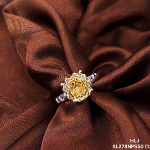 Gold ring with a floral design on brown fabric