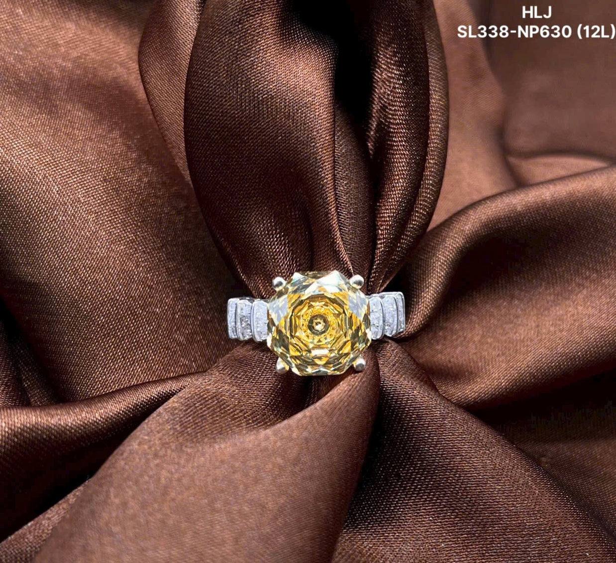 Gold ring with a large central gemstone and smaller stones on a brown fabric background