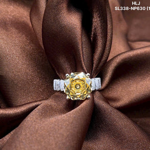 Gold ring with a large central gemstone and smaller stones on a brown fabric background