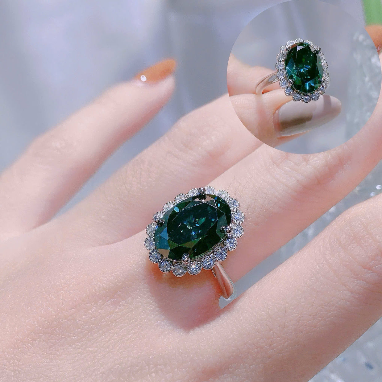 Green gemstone ring on a hand with a blurred background