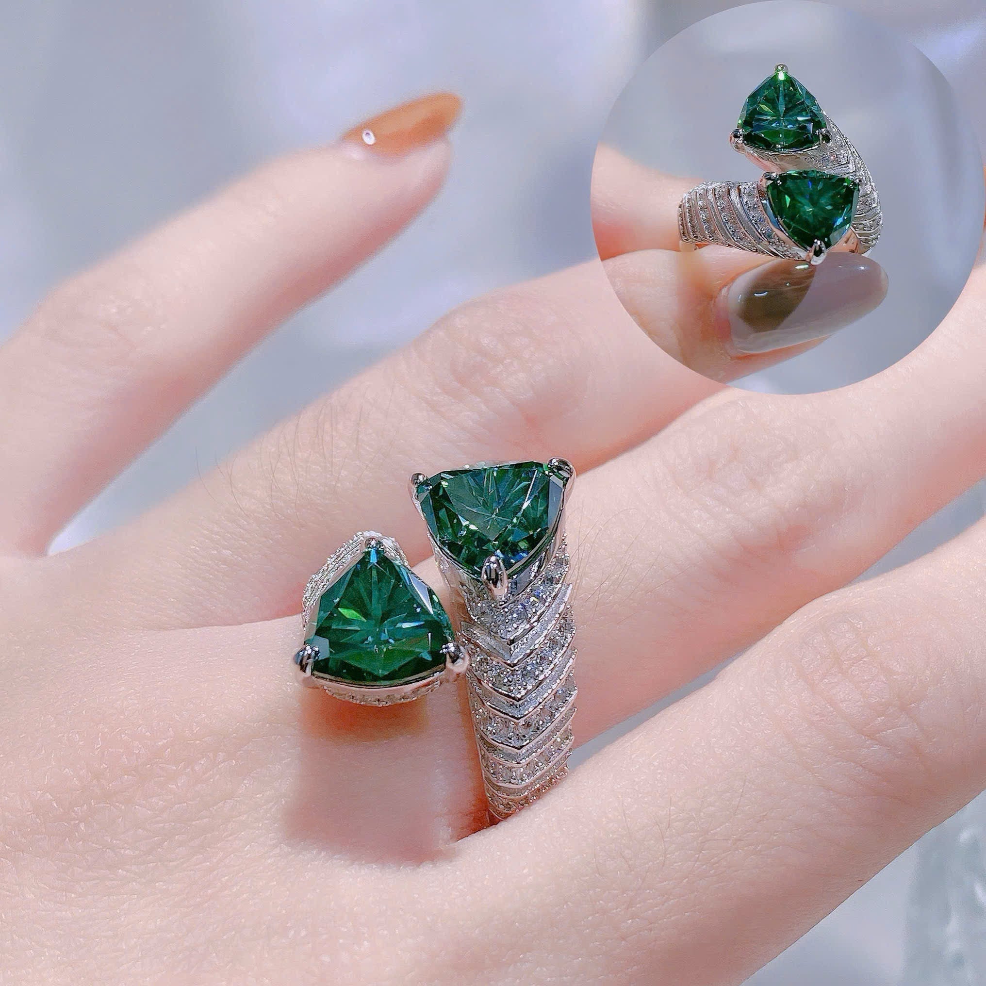 Green gemstone ring on a hand with a blurred background