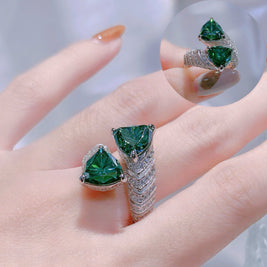 Green gemstone ring on a hand with a blurred background
