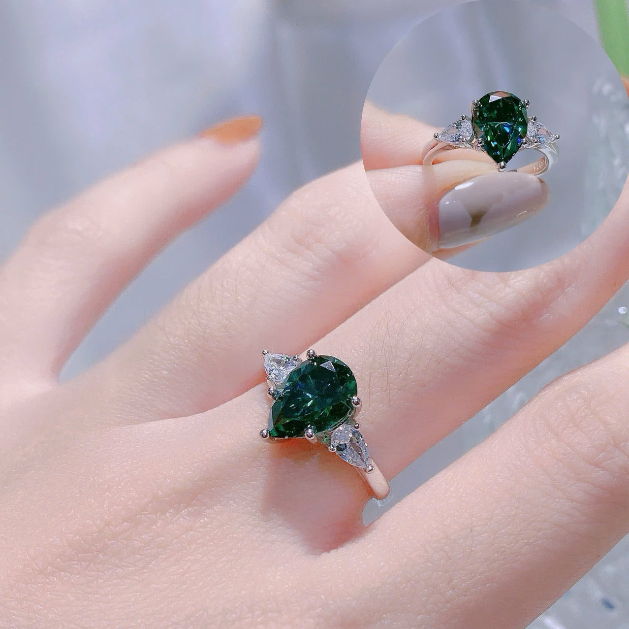 Green gemstone ring on a hand with a blurred background