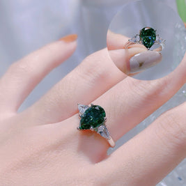 Green gemstone ring on a hand with a blurred background