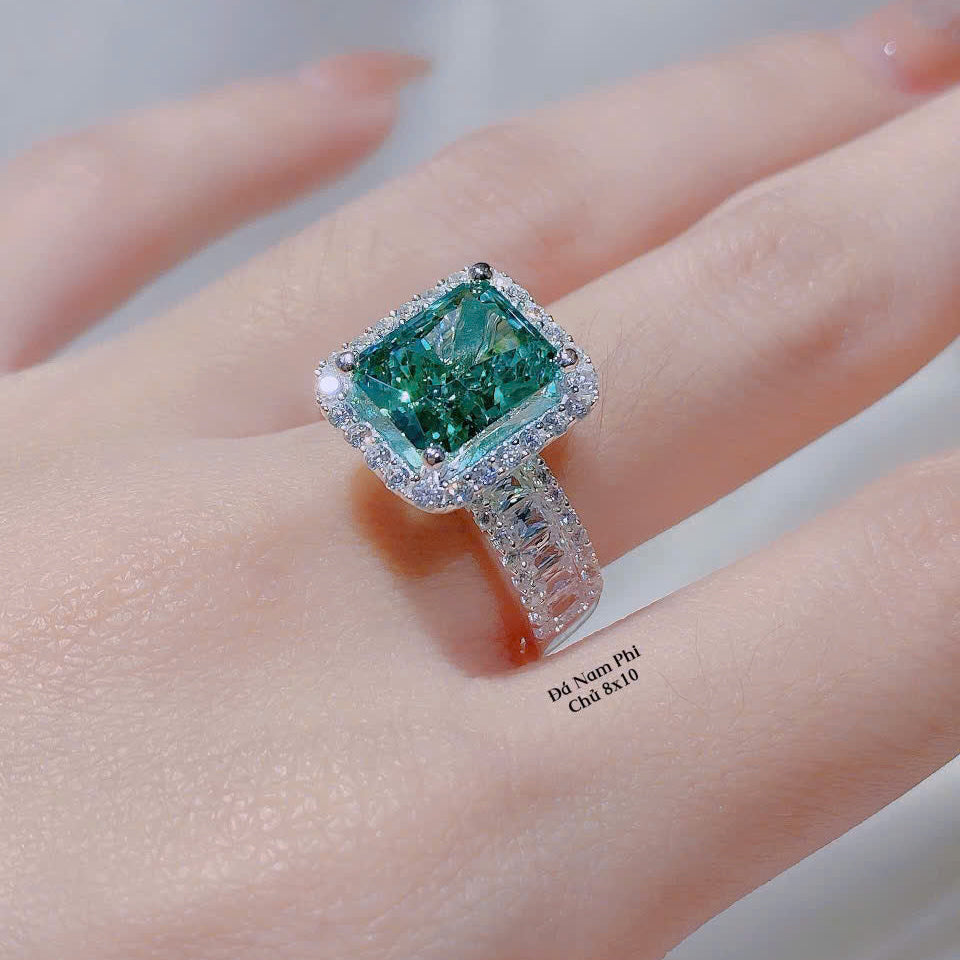 Green gemstone ring on a hand with a blurred background