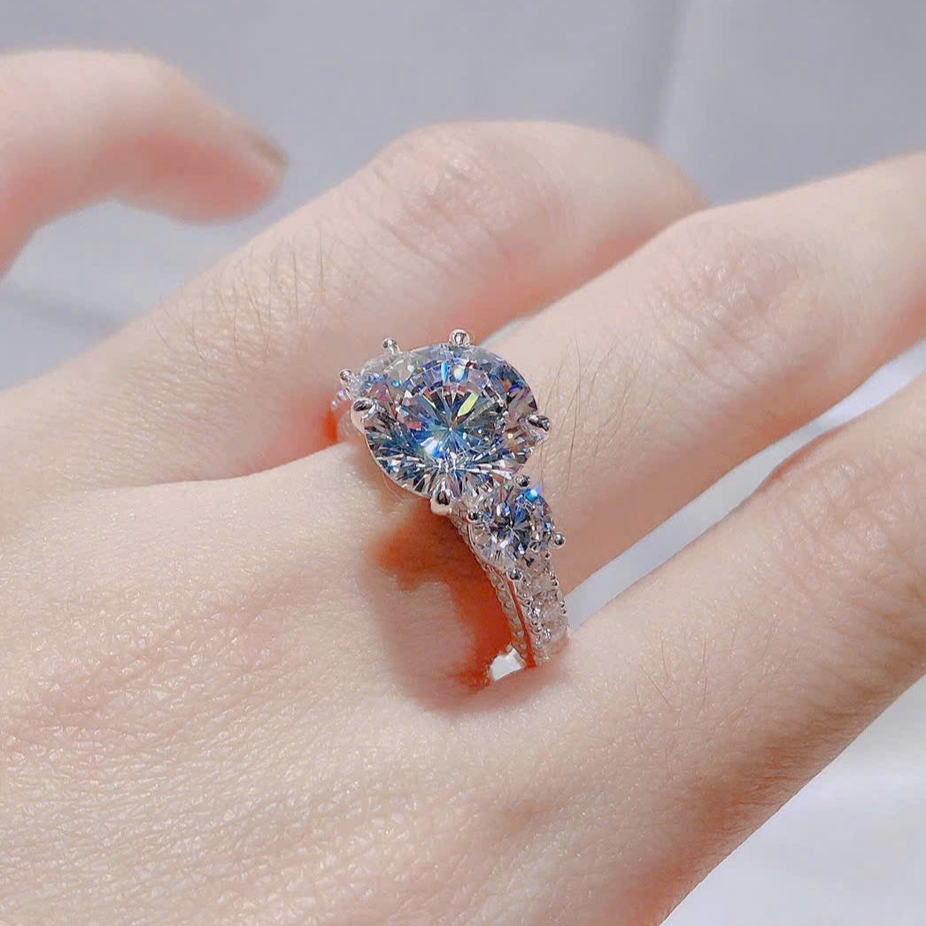 Heart-shaped diamond ring on a hand with a neutral background