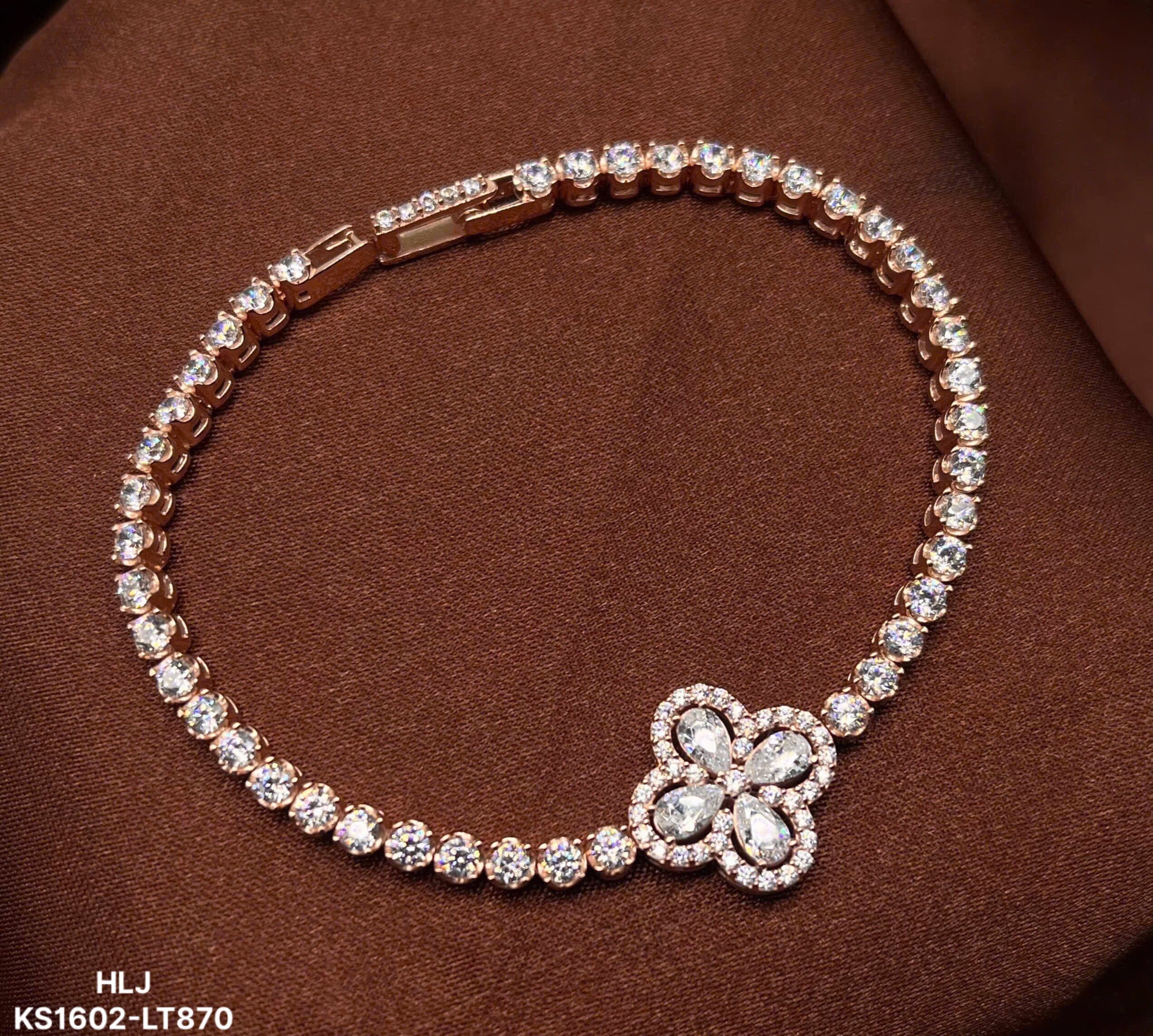 Jewelry bracelet with floral clasp on a brown background