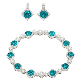 Jewelry set with bracelet and earrings featuring blue gemstones on a white background
