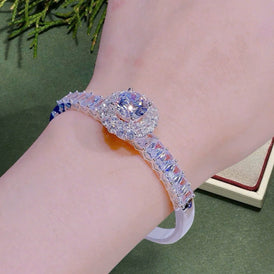 Luxury bracelet with gemstones on a wrist against a green background