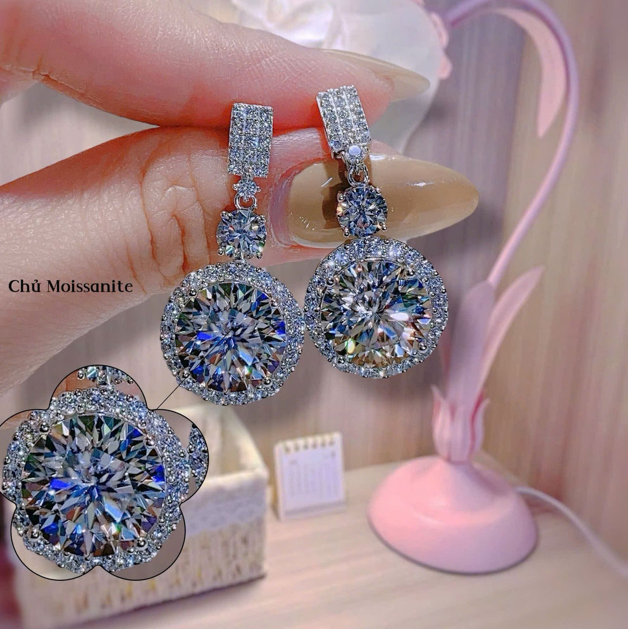 Luxury diamond earrings held by a hand with a blurred background