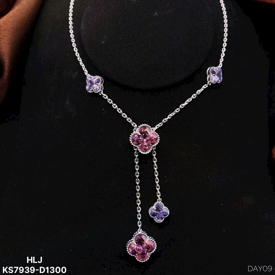 Necklace with purple floral pendants on a black background
