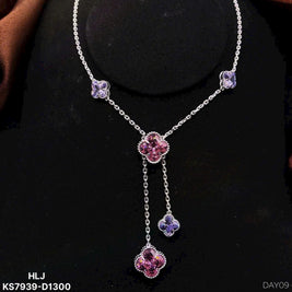Necklace with purple floral pendants on a black background