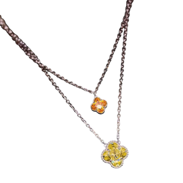 Necklace with two floral pendants, one yellow and one orange, on a white background.