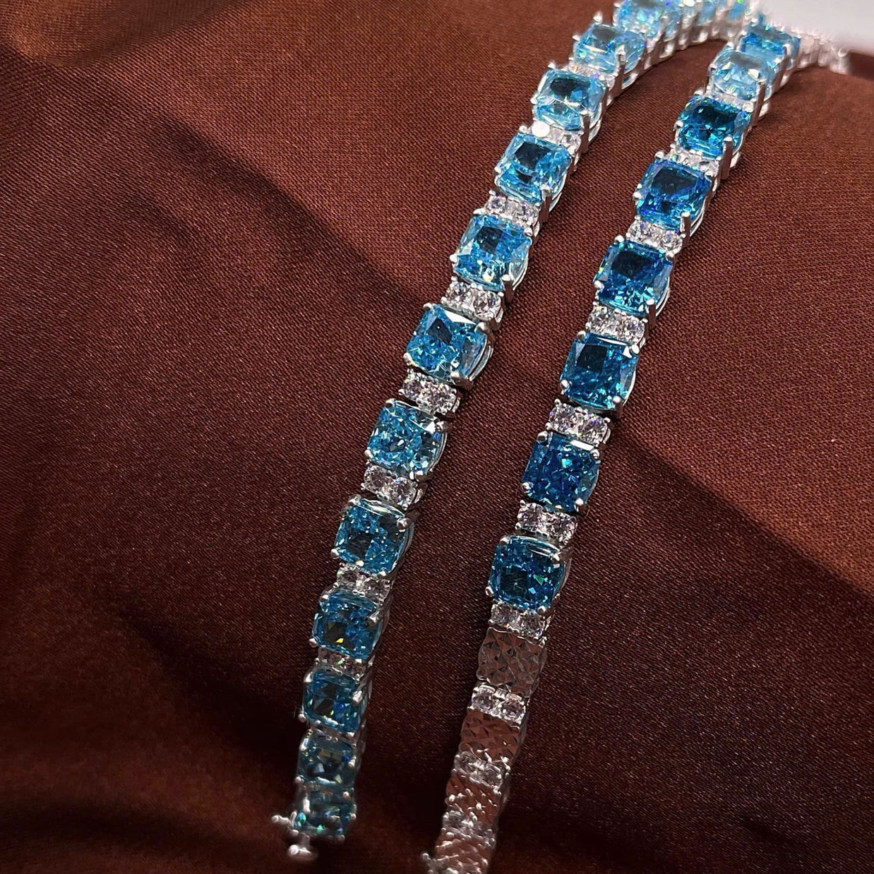 Pair of blue gemstone earrings on a brown fabric background