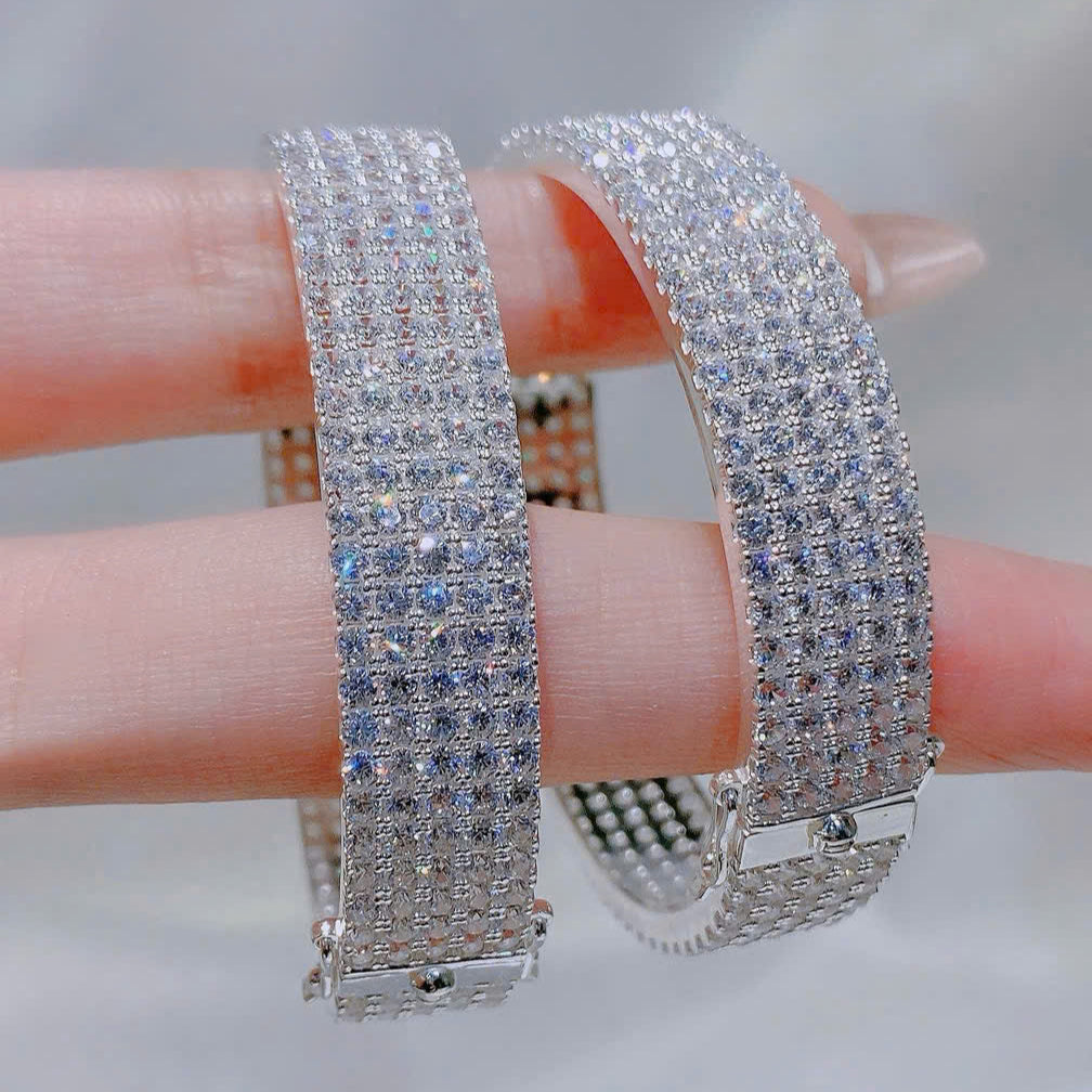 Pair of diamond-encrusted bracelets on a finger with a blurred background