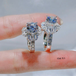 Pair of diamond earrings held on a finger with a neutral background111